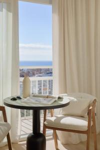 a table and chairs in a room with a window at Meliá Lloret de Mar in Lloret de Mar