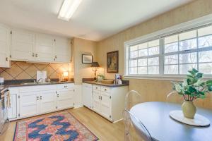 cocina con armarios blancos, mesa y ventana en Oxford Getaway Walk to Oxford Square!, en Oxford