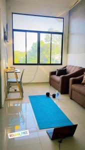 Apartamentos Tamarindo Guanacaste 3 في غواناكاستي: غرفة معيشة مع أريكة وسجادة زرقاء