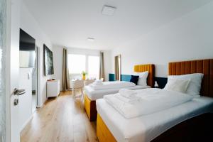 um quarto de hotel com duas camas e uma mesa em Jenapartments for7 Boxspring & Smart TV & Waschmaschine em Jena