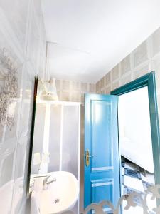 baño con puerta azul y lavamanos en Hotel Agur, en Fuengirola