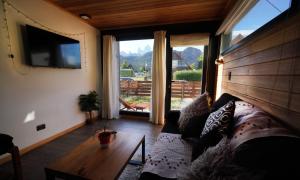 a living room with a couch and a large window at Güer Aike Mejor Tiny house c/ vista al Fitz Roy in El Chalten