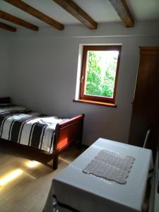 a bedroom with a bed and a window and a table at Hortensja in Iława