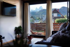 a living room with a couch and a large window at Güer Aike Mejor Tiny house c/ vista al Fitz Roy in El Chalten
