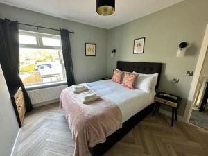 a bedroom with a large bed and a window at Bronte Cottage - Quirky, central, 2bed, seaside in Hornsea