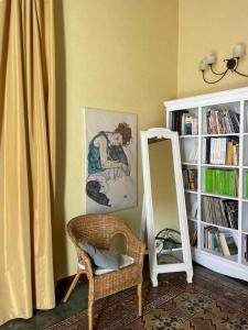 Habitación con espejo, silla y estante para libros. en Inn The Garden, en Catania