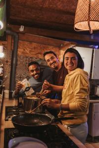 un grupo de personas de pie en una cocina preparando comida en La Ventana Azul Surf Hostel, en Las Palmas de Gran Canaria