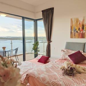 a bedroom with a bed with a view of the water at 海景套房 3房3厕 可8-12人Danga Bay Country Garden YI JIA名宿 in Johor Bahru