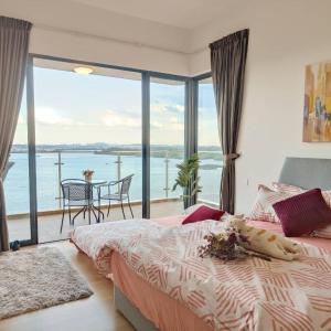 a bedroom with a bed and a view of the water at 海景套房 3房3厕 可8-12人Danga Bay Country Garden YI JIA名宿 in Johor Bahru