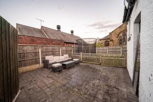 a patio with a couch and a fence at Bannerdale Villa 5 bedroom in Nether Edge