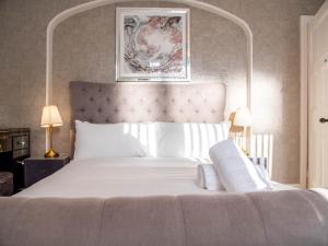 a bedroom with a large white bed with a large headboard at Bannerdale Villa 5 bedroom in Nether Edge