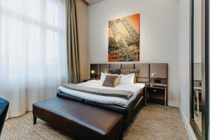 een hotelkamer met een bed en een groot raam bij Terhills Hotel in Maasmechelen