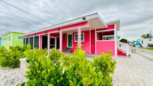 una casa rosa y verde al lado de una calle en Flamingo Tiny Home, en Sarasota