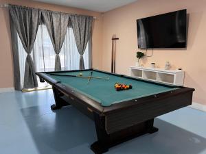 a pool table in a living room with a tv at Flamingo Tiny Home in Sarasota