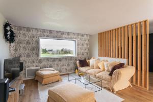 a living room with a couch and a tv at La perle de mer - Charmante maison avec jacuzzi in Erquy