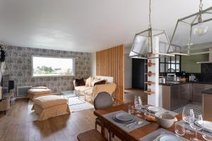 een woonkamer met een bank en een tafel bij La perle de mer - Charmante maison avec jacuzzi in Erquy