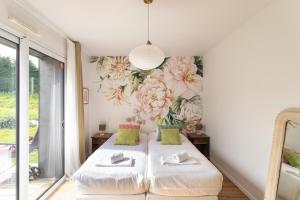 een slaapkamer met een bed met bloemenbehang bij La perle de mer - Charmante maison avec jacuzzi in Erquy