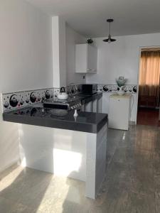 a white kitchen with a black counter top at Apartamento en Pisco in Pisco
