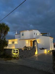 una casa blanca con una pared de piedra delante de ella en Casa Malìa Luxury Guest House, en Luz