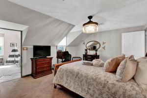 a bedroom with a bed and a flat screen tv at Gorgeous historic Victorian with 8 bedroom/4 baths in Wildwood