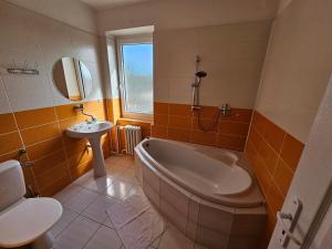 a bathroom with a tub and a sink at Hotel Union in Louny