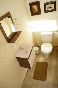 a bathroom with a white toilet and a sink at Casa de 4 suites, perto do Thermas Water Park e Águas de são Pedro in São Pedro
