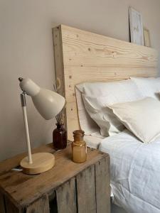 eine Lampe auf einem Holztisch neben einem Bett in der Unterkunft L'appart Saint-Laurent in Chalon-sur-Saône