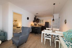 1 dormitorio y sala de estar con mesa y sillas. en Playa d'Or 16 / Cala D'Or / Mallorca en Cala D'Or