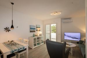 a living room with a table and a tv at Playa d'Or 16 / Cala D'Or / Mallorca in Cala d´Or