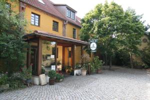 a building with a clock on the side of it at Hotel Wenzels Hof in Zwethau