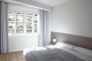 Habitación blanca con cama y ventana en Sant Jordi Apartments Sagrada Familia en Barcelona