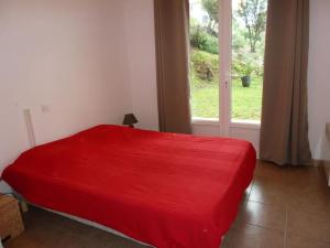 普羅普里亞諾的住宿－T3 en rdj pour 6 pers dans résidence avec piscine，窗户客房内的一张红色的床