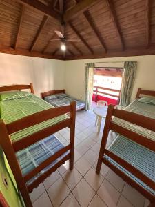 ガロパバにあるPousada Via Ferrugemの二段ベッド2台とテーブルが備わる客室です。