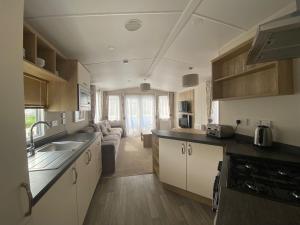 uma cozinha com um lavatório e uma sala de estar em 11 Meadow View em Newquay