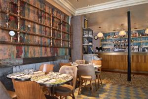 a restaurant with tables and chairs and a bar at Le Robinet d'Or Paris Canal Saint Martin in Paris