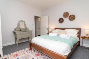 een slaapkamer met een bed met een spiegel en een dressoir bij Little Boat: A Modern Beachside Flat in Bournemouth