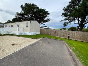 a mobile home parked in a yard next to a fence at 11 Meadow View in Newquay
