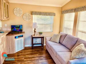 sala de estar con sofá y TV en Pinecraft Cottage Tiny Home, en Sarasota