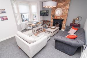 a living room with two couches and a fireplace at Little Boat: A Modern Beachside Flat in Bournemouth