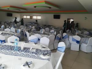 einen Bankettsaal mit weißen Tischen und Stühlen in der Unterkunft Pensao Martins in Maputo