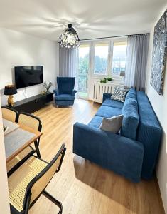 a living room with a blue couch and a table at Apartament 55 in Węgierska Górka