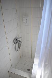 une salle de bain avec une douche avec un rideau de douche dans l'établissement Μαγευτική Περδικιώτικη Μεζονέτα, à Perdika