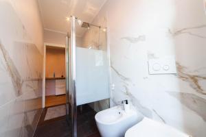 a white bathroom with a toilet and a shower at Casa Margherita C in Bergamo