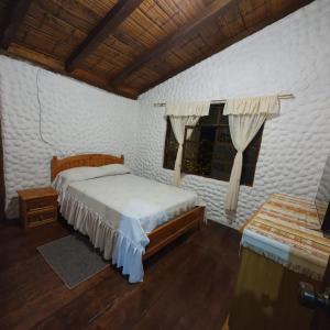 een slaapkamer met een groot bed en een raam bij El Colibrí Azul in Quito