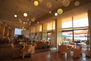a dining room with tables and chairs and windows at Hotel On Plonge Junior in Mamaia