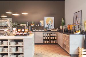 a kitchen with a counter with plates on it at acora Augsburg Living the City - Apartments in Neusäß