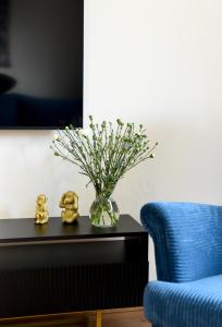 a vase of flowers on a table next to a blue couch at Apartament 55 in Węgierska Górka