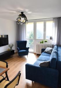 a living room with a blue couch and chairs at Apartament 55 in Węgierska Górka