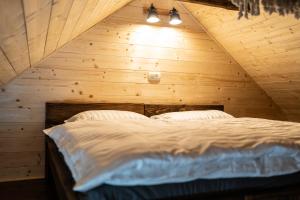 a bedroom with a bed in a wooden attic at Apartmaji Babi in Markovci