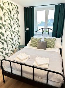 sypialnia z łóżkiem z zielonymi zasłonami i oknem w obiekcie Apartament 55 w Węgierskiej Górce